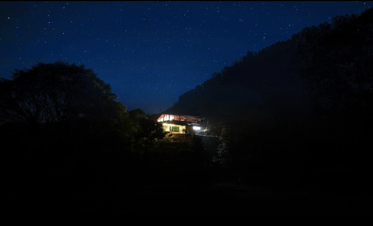 Magic Valley camp glowing gold on the hilltop at night