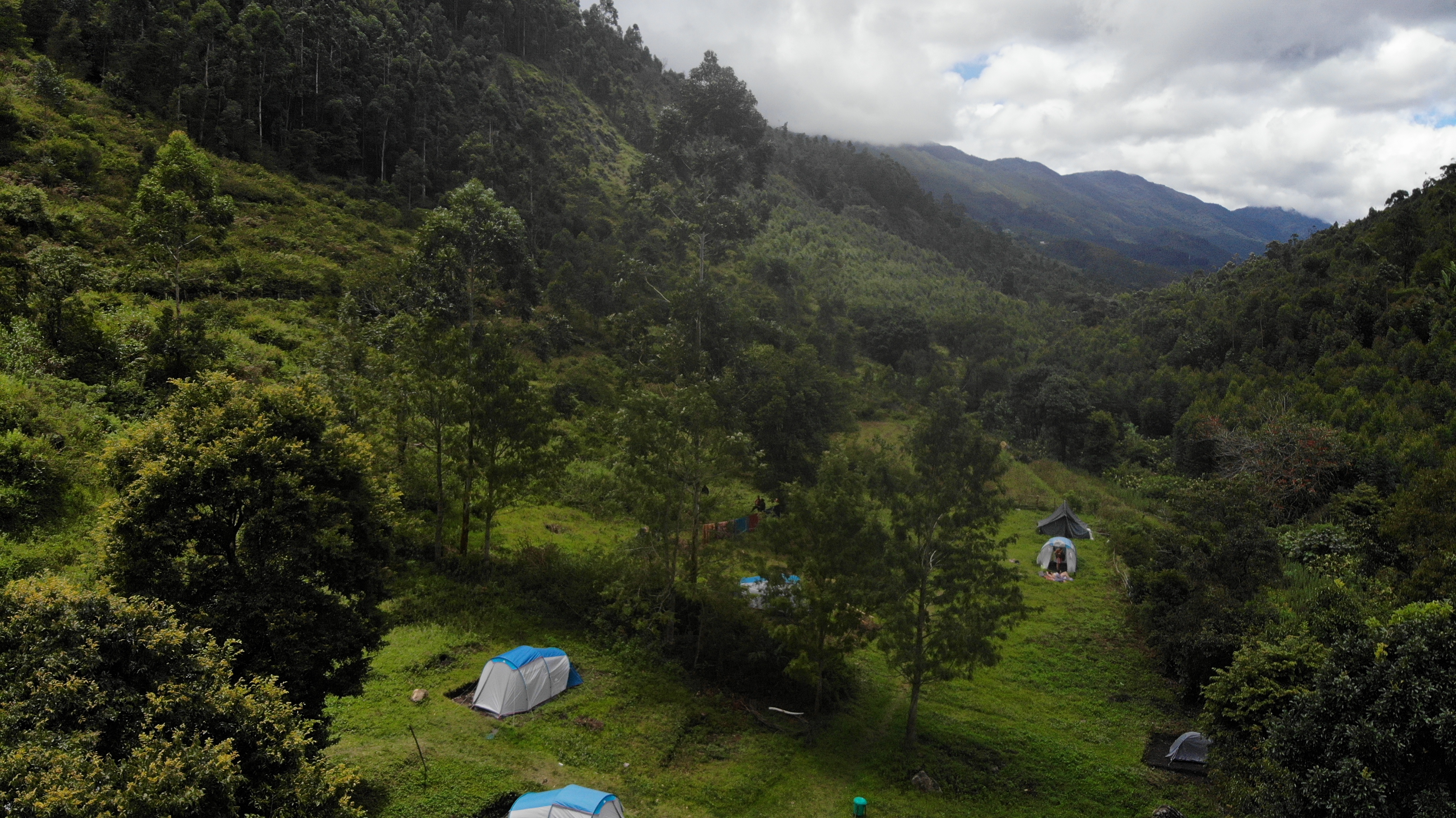 Aerial view of camping tents nestled in the green valley at Magic Valley
